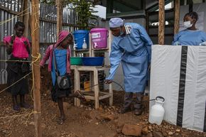 Dr. Gilbert Kasereka (42) desinfiziert mit chloriertem Wasser die Füße eines Mädchens. Komanda, Provinz Ituri, Demokratische Republik Kongo, 22. Mai 2019. Der Ausbruch von Ebola im vergangenen Jahr in der Demokratischen Republik Kongo ist der zweitschlimmste in der Geschichte, hat mehr als 1.900 Menschen infizierte und bis Anfang Juni 2019 über 1.300 Menschen getötete und verschärft die ohnehin schon schwierige Situation für Hilfsorganisationen.