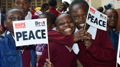 Eine Kindergruppe mit Fahnen in den Händen.