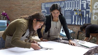 Zwei Frauen beim zuschneiden eines Stoffes.