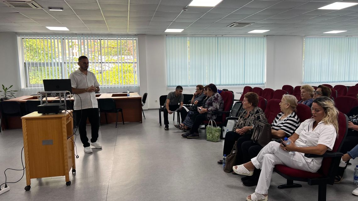 Ein Vortragender spricht in einem Vortragssaal vor Publikum.